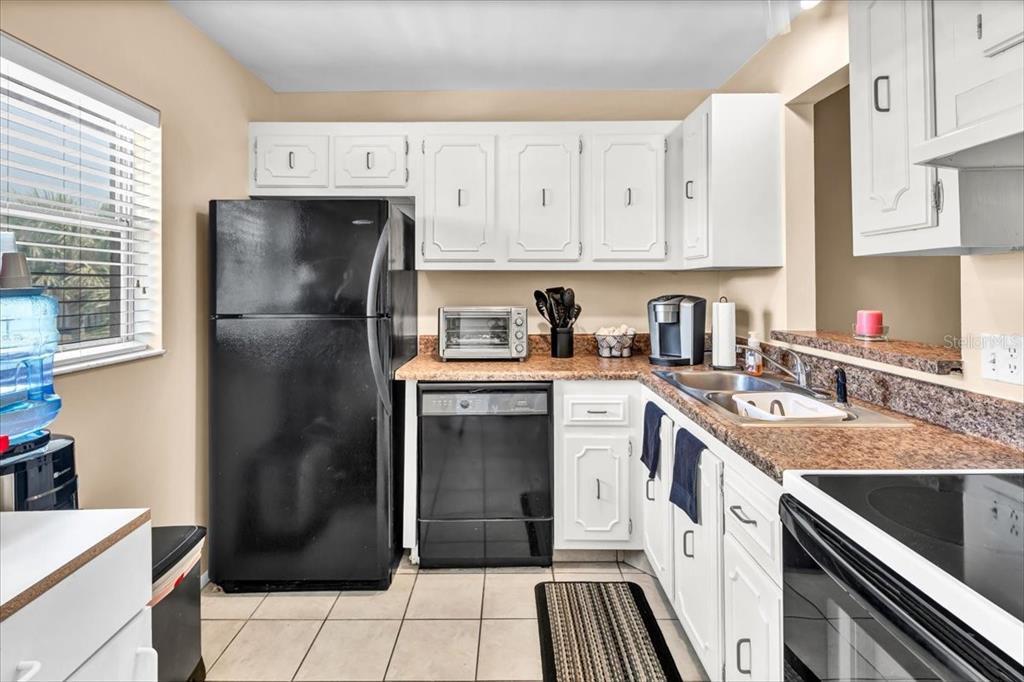 11485 Oakhurst Road, Unit 200321 Largo, FL 33774 - Photo 4 of 28 a kitchen with a white cabinets and refrigerator