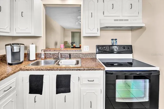 a kitchen with stainless steel appliances granite countertop a sink stove and cabinets