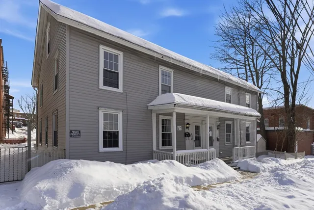 a view of a house with a yard covered in snow