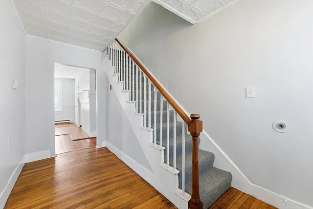 a view of entryway and hall with wooden floor
