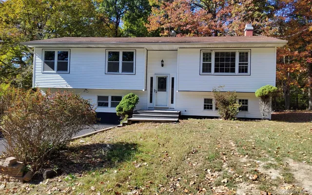 a view of a house with a yard and sitting area