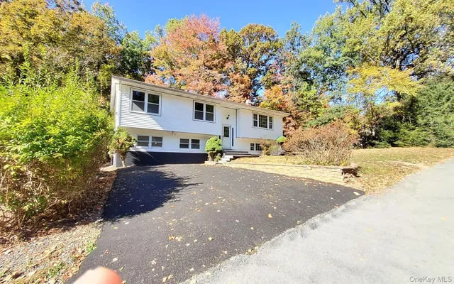 a front view of a house with a yard and trees