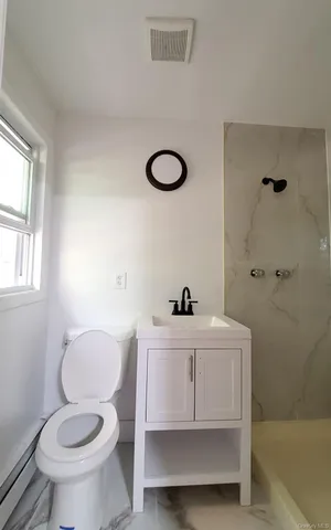 a bathroom with a sink a toilet and a window