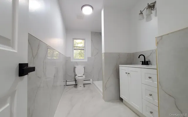 a bathroom with a sink a toilet a mirror and shower