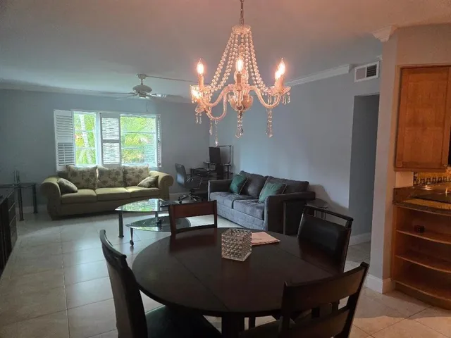 a living room with a bed and a lamp on dresser