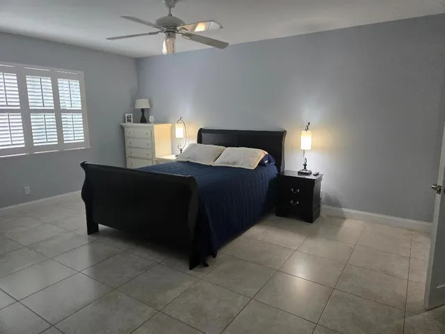 a living room with a bed and a lamp on dresser