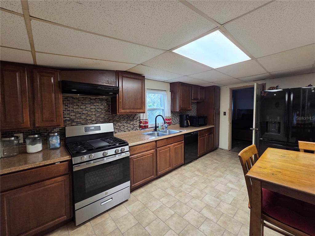 124 East F Street Frostproof, FL 33843 - Photo 12 of 37 a kitchen with stainless steel appliances kitchen island granite countertop a stove refrigerator and cabinets