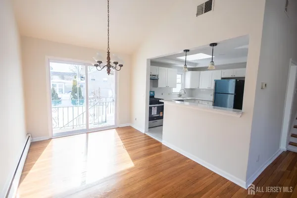 a kitchen with kitchen island a counter top space a sink stainless steel appliances and cabinets