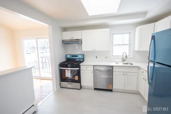 a kitchen with white cabinets and white appliances