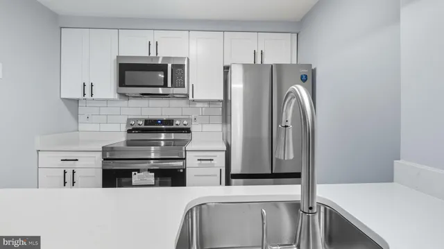 a kitchen with stainless steel appliances a refrigerator stove and microwave