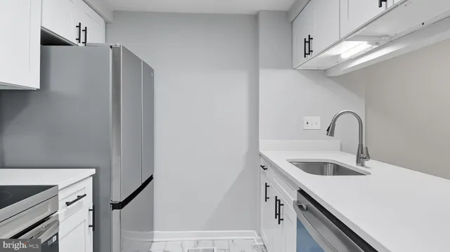a kitchen with stainless steel appliances a sink and a refrigerator