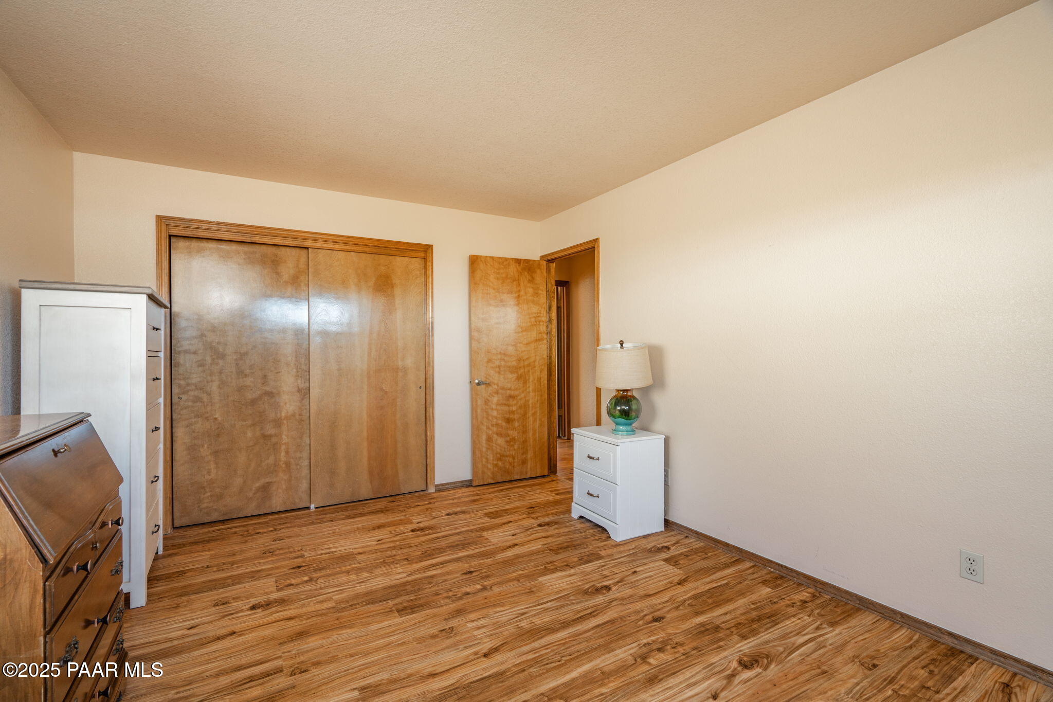 11992 Rawhide Ridge Dewey, AZ 86327 - Photo 20 of 46 a view of an empty room with wooden floor and a window