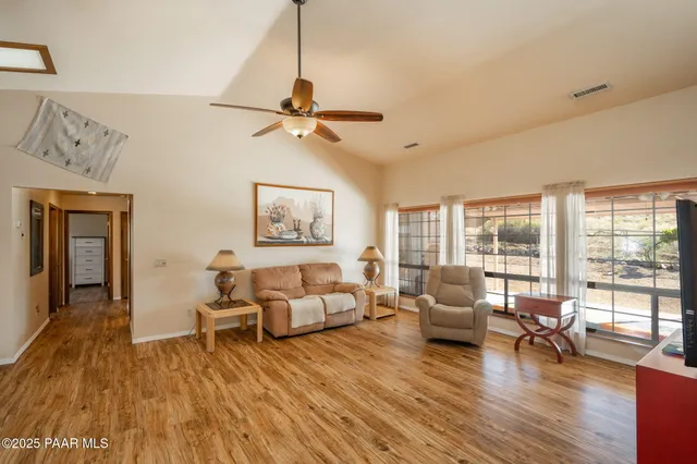 a dining hall with stainless steel appliances granite countertop a dining table and chairs with the cabinets