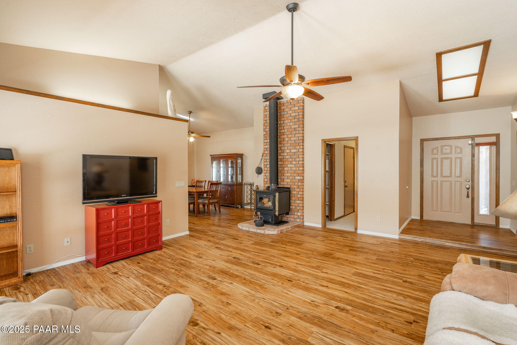 11992 Rawhide Ridge Dewey, AZ 86327 - Photo 6 of 46 a view of a livingroom with a flat screen tv wooden floor and a ceiling fan