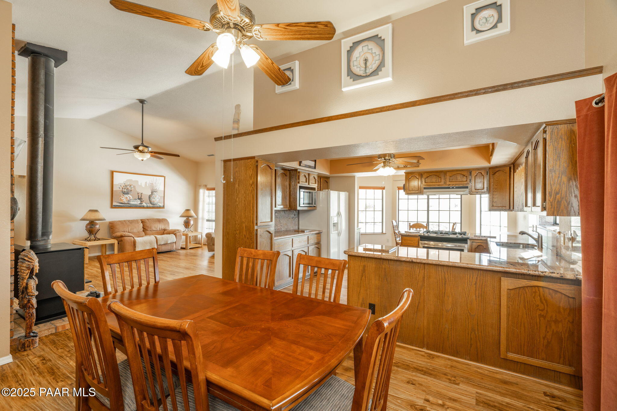 11992 Rawhide Ridge Dewey, AZ 86327 - Photo 7 of 46 a dining hall with stainless steel appliances granite countertop a dining table and chairs with the cabinets
