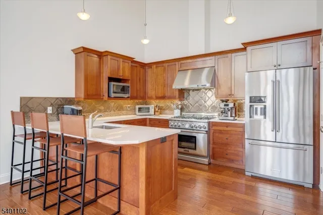 a kitchen with granite countertop a refrigerator stove top oven and sink