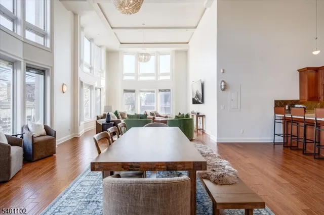 a living room with furniture a large window and wooden floor