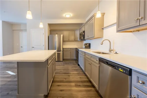 a kitchen with stainless steel appliances a sink stove and cabinets