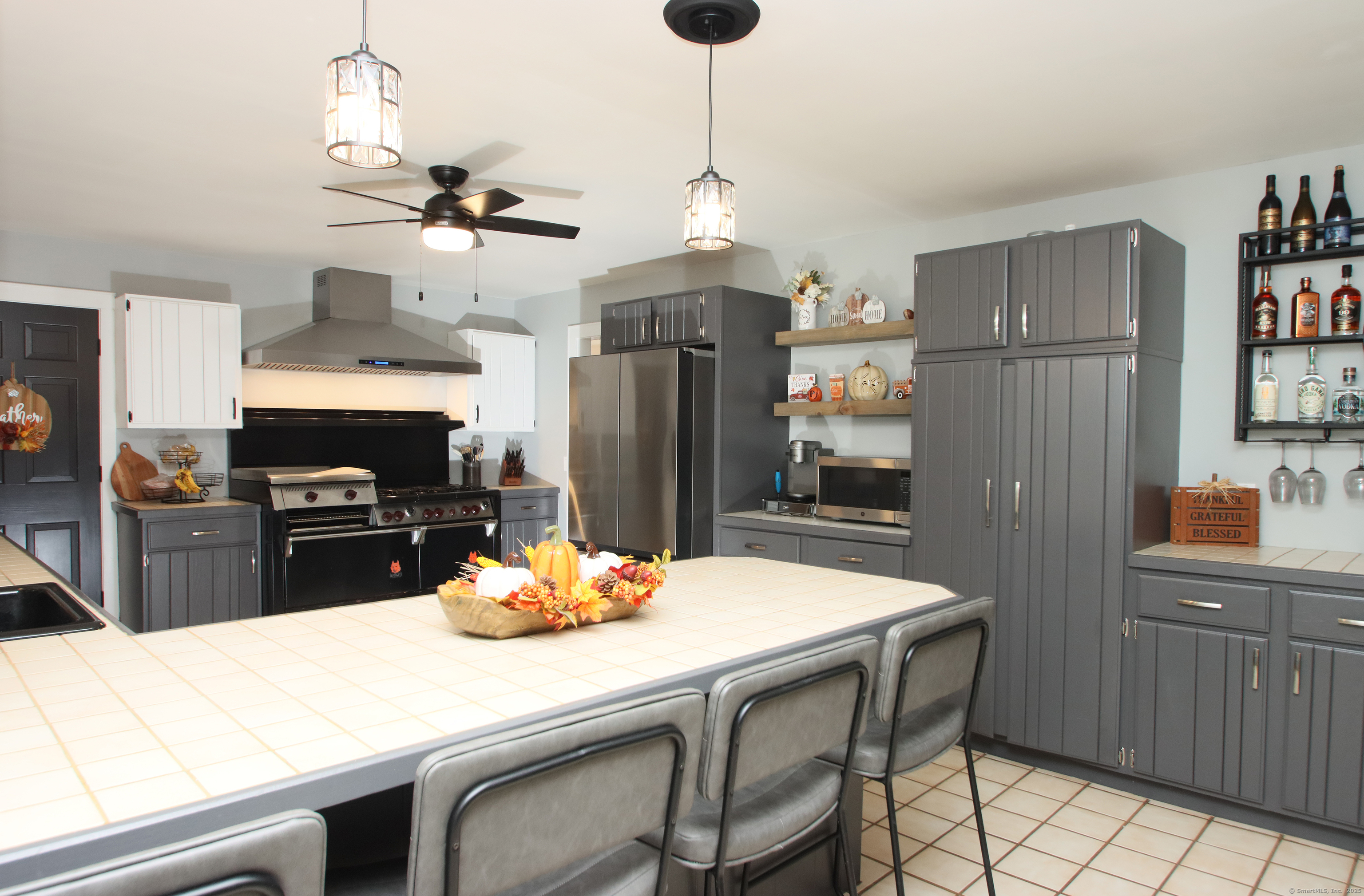 821 Essex Road Westbrook, CT 06498 - Photo 12 of 40 a kitchen with stainless steel appliances granite countertop a refrigerator a stove a sink dishwasher with a dining table and chairs