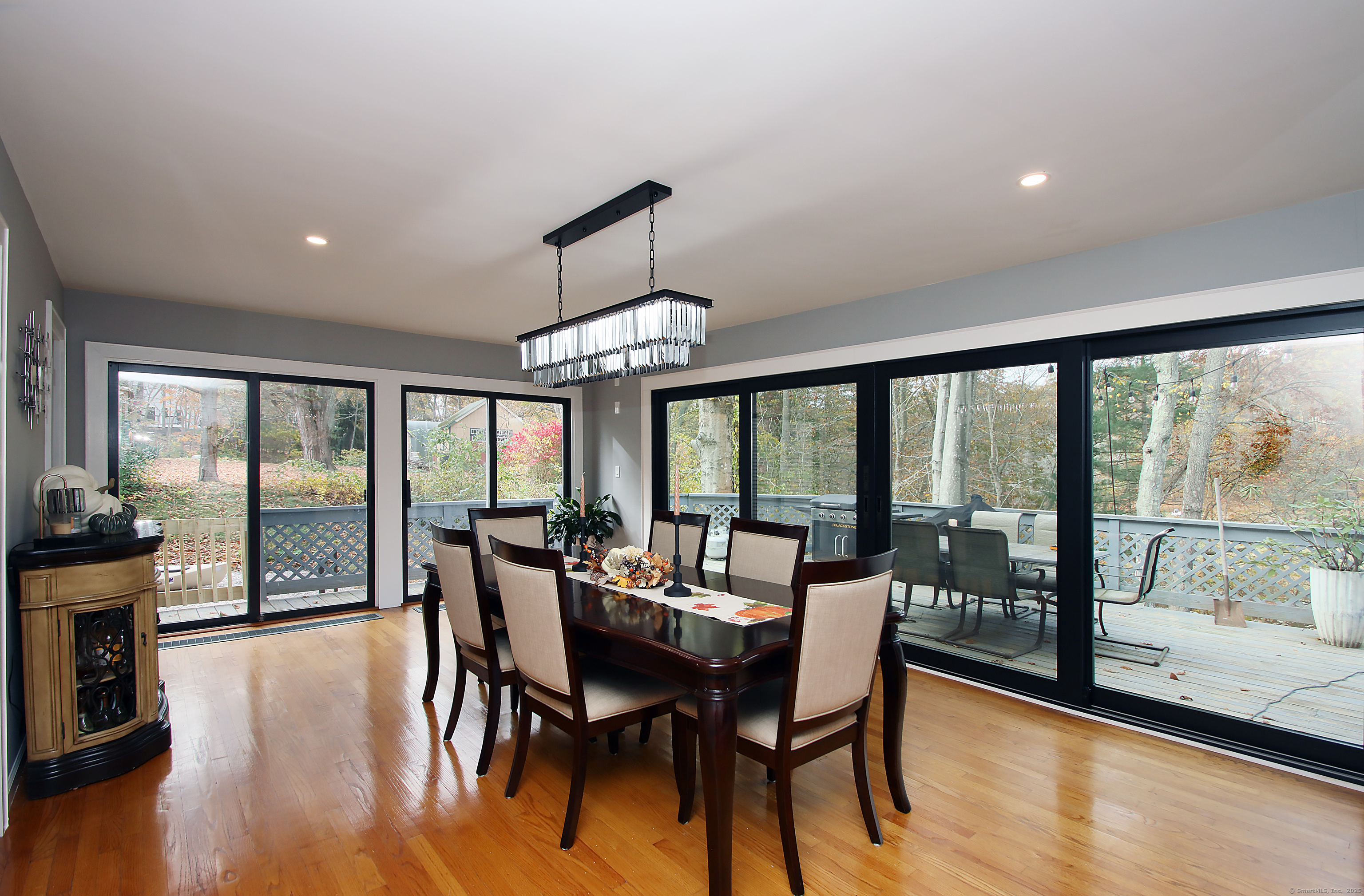 821 Essex Road Westbrook, CT 06498 - Photo 21 of 40 a view of a dining room with furniture large windows and wooden floor