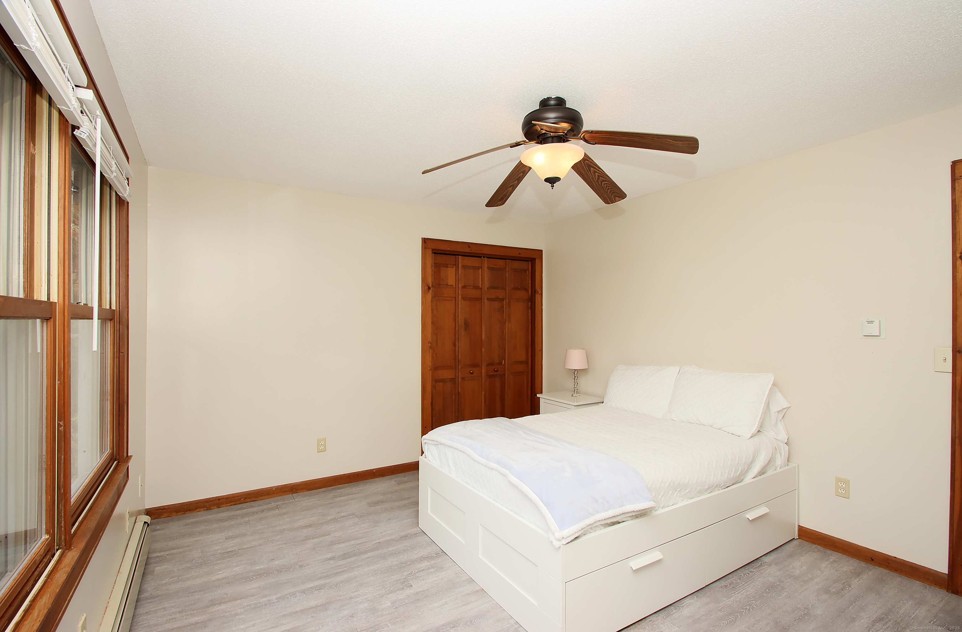 821 Essex Road Westbrook, CT 06498 - Photo 30 of 40 a bedroom with a bed and a chandelier