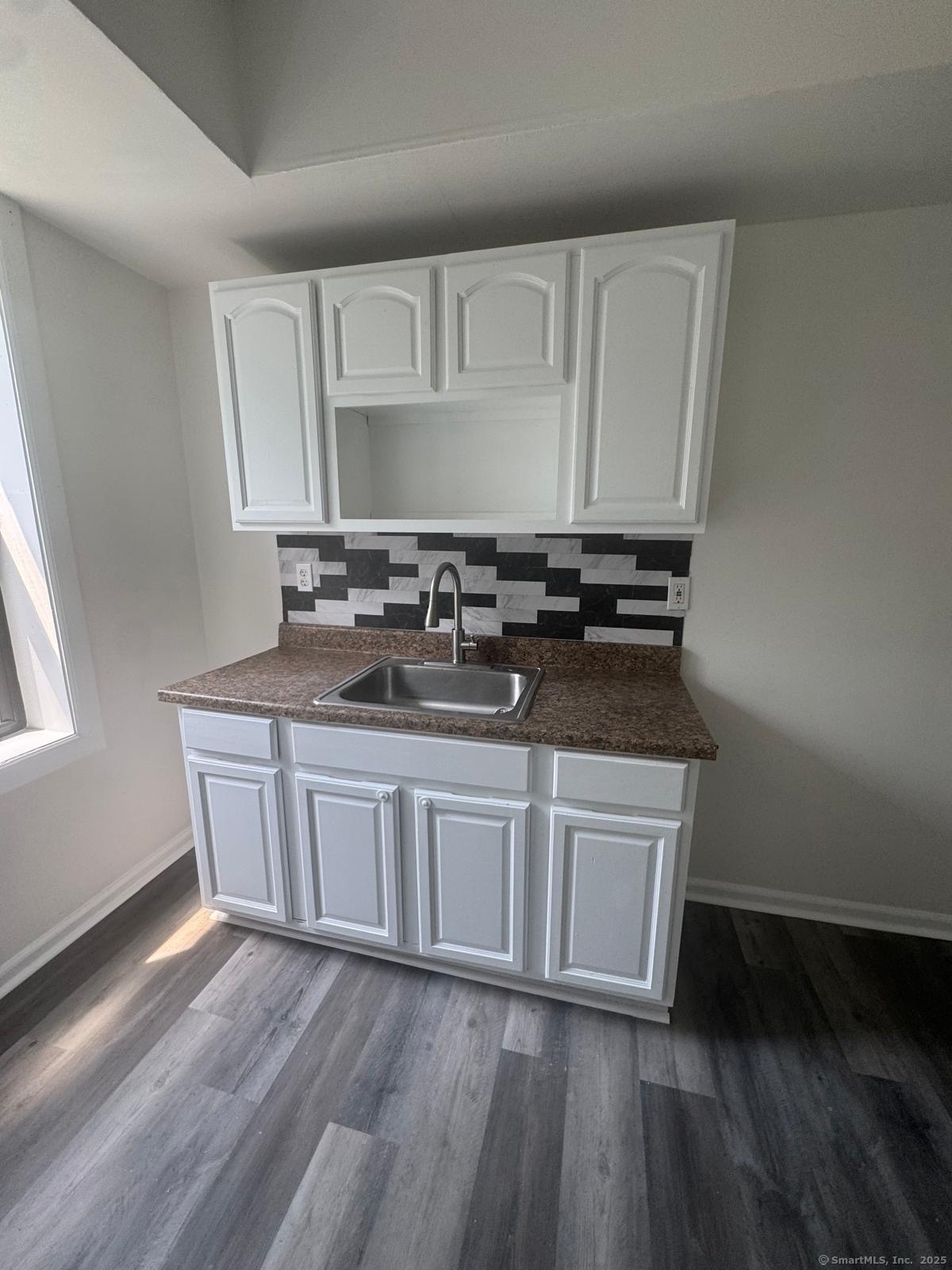 a kitchen with granite countertop a sink and cabinets