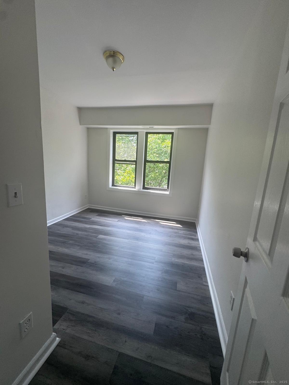 1071 Pembroke Street, Unit 3E Bridgeport, CT 06608 - Photo 3 of 3 wooden floor in an empty room with a window