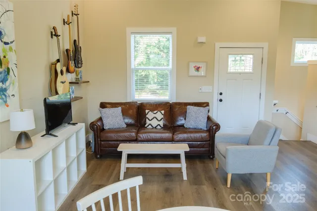 a living room with furniture a desk and chair with wooden floor