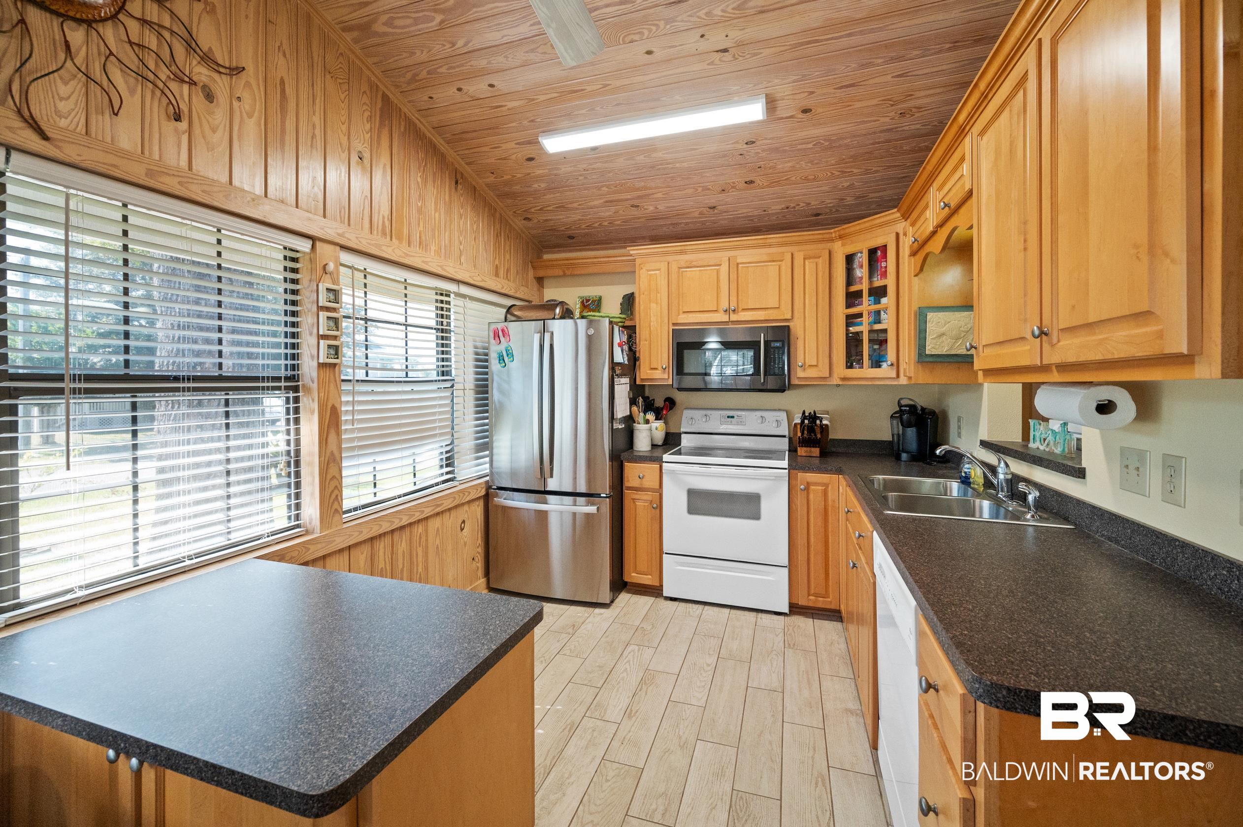5392 Ornacor Avenue Orange Beach, AL 36561 - Photo 10 of 48 Kitchen with light wood-type flooring, vaulted ceiling, appliances with stainless steel finishes, wooden ceiling, and sink