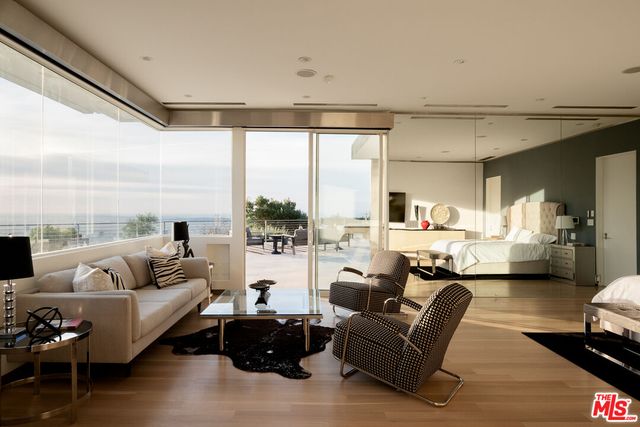 a living room with furniture large windows and a fireplace