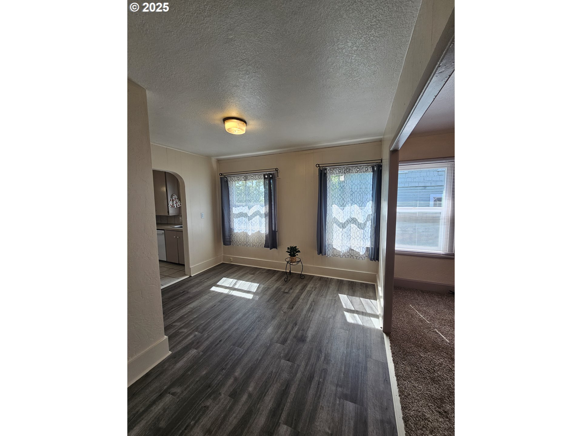 1760 West Broadway Eugene, OR 97402 - Photo 8 of 40 a view of an empty room with wooden floor and a window