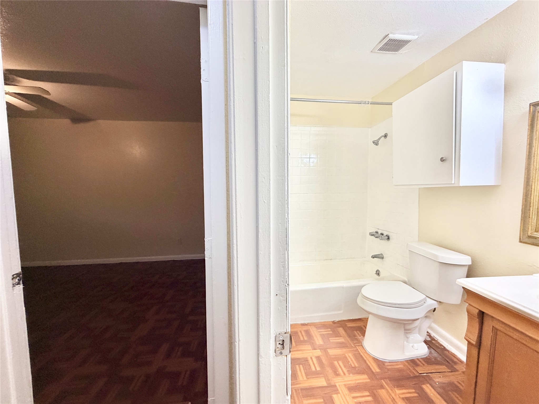 6257 Manor Road, Unit B Austin, TX 78723 - Photo 24 of 38 Bathroom featuring a white bathtub with tile surround, toilet, and vanity with a white countertop