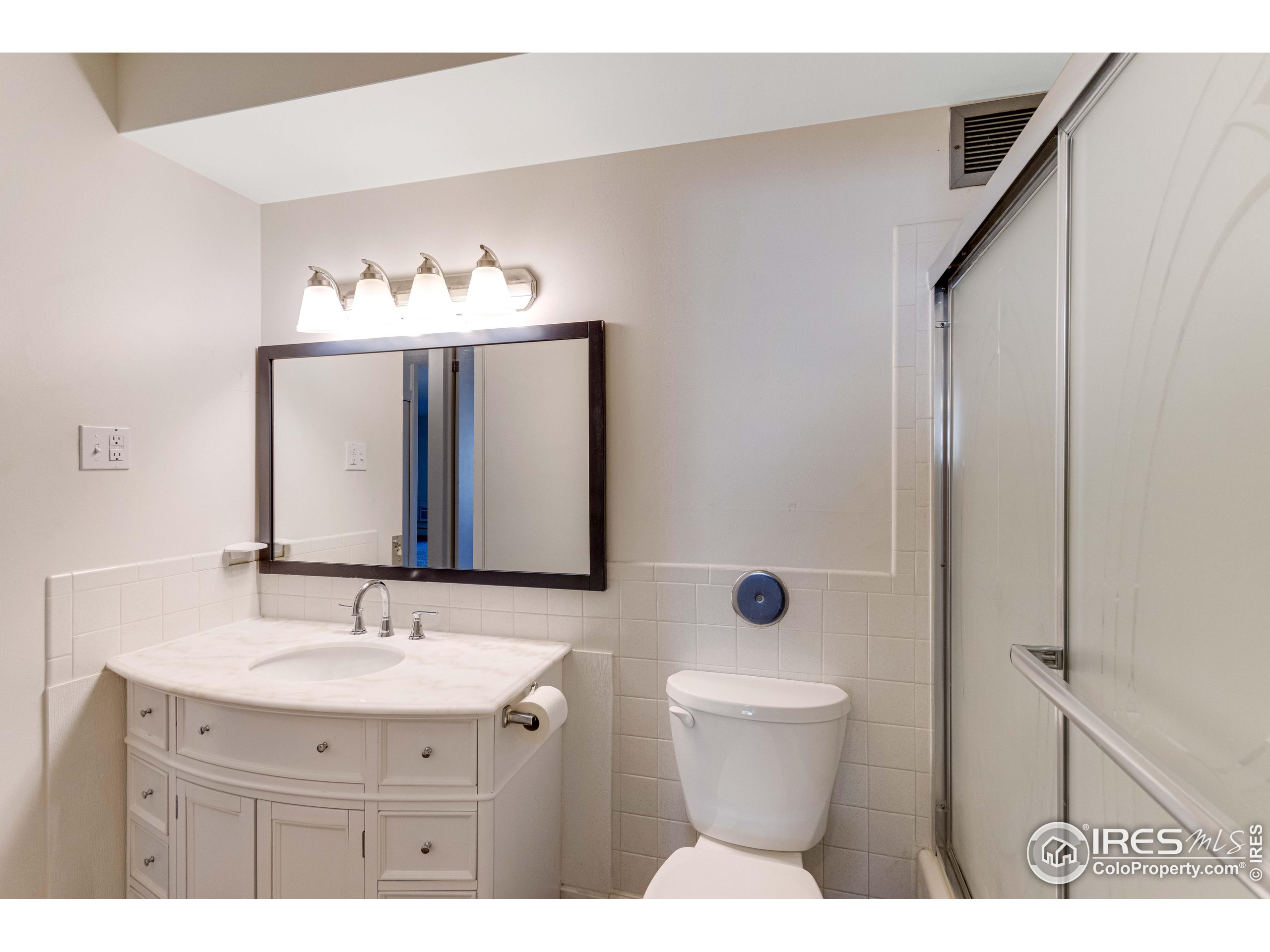735 South Alton Way Denver, CO 80247 - Photo 14 of 29 a bathroom with a toilet sink and mirror