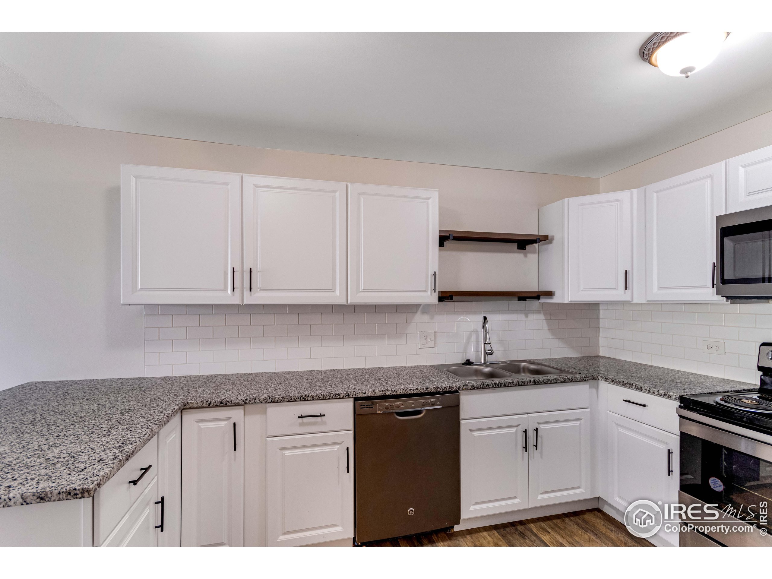 735 South Alton Way Denver, CO 80247 - Photo 4 of 29 a kitchen with granite countertop white cabinets and stainless steel appliances