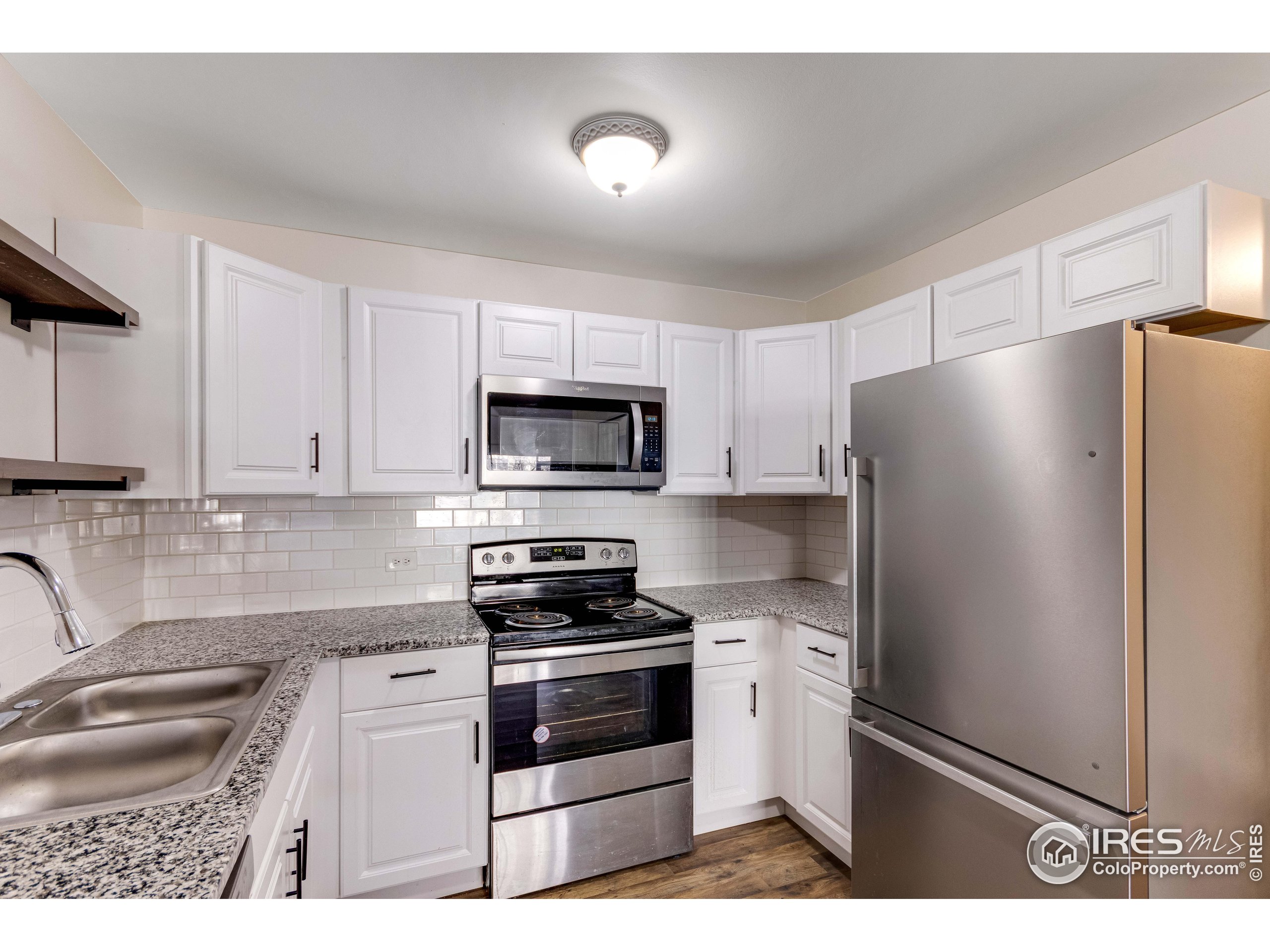 735 South Alton Way Denver, CO 80247 - Photo 5 of 29 a kitchen with stainless steel appliances a refrigerator stove and sink