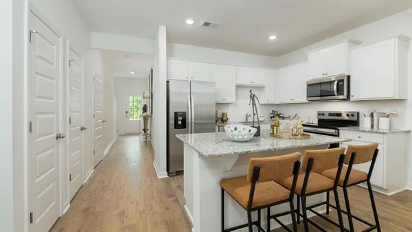 a kitchen with stainless steel appliances granite countertop a stove a sink a refrigerator and a refrigerator with wooden floor