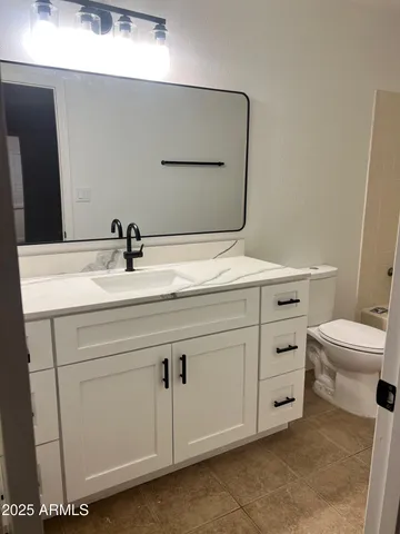 a bathroom with a sink toilet and mirror