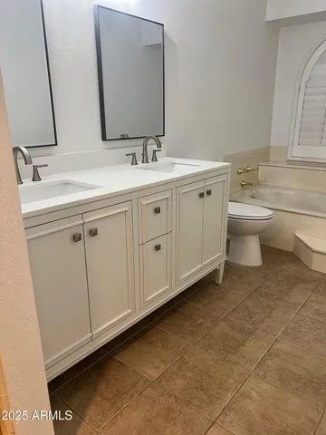 a bathroom with a double vanity sink mirror and toilet