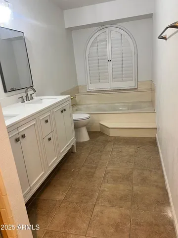 a bathroom with a double vanity sink a toilet and a mirror
