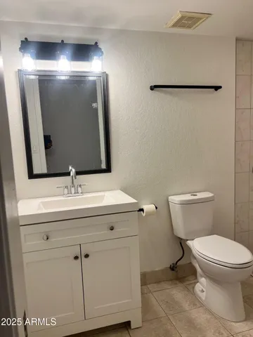a bathroom with a toilet a sink and mirror