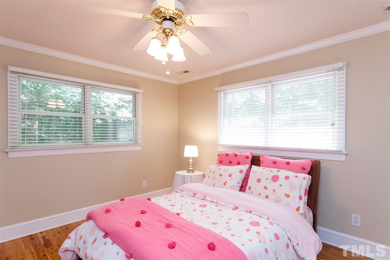 4921 Springwood Drive Raleigh, NC 27613 - Photo 19 of 25 a bedroom with a bed and a chandelier