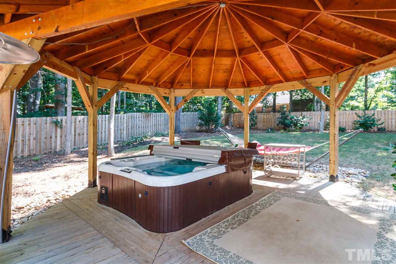 4921 Springwood Drive Raleigh, NC 27613 - Photo 21 of 25 a view of a backyard with table and chairs under an umbrella