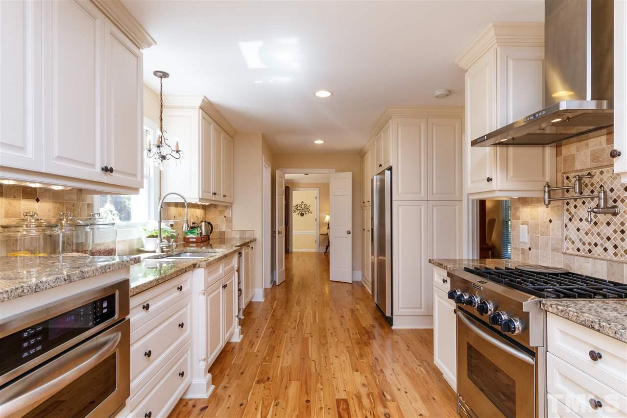 4921 Springwood Drive Raleigh, NC 27613 - Photo 8 of 25 a kitchen with stainless steel appliances granite countertop a stove and a refrigerator