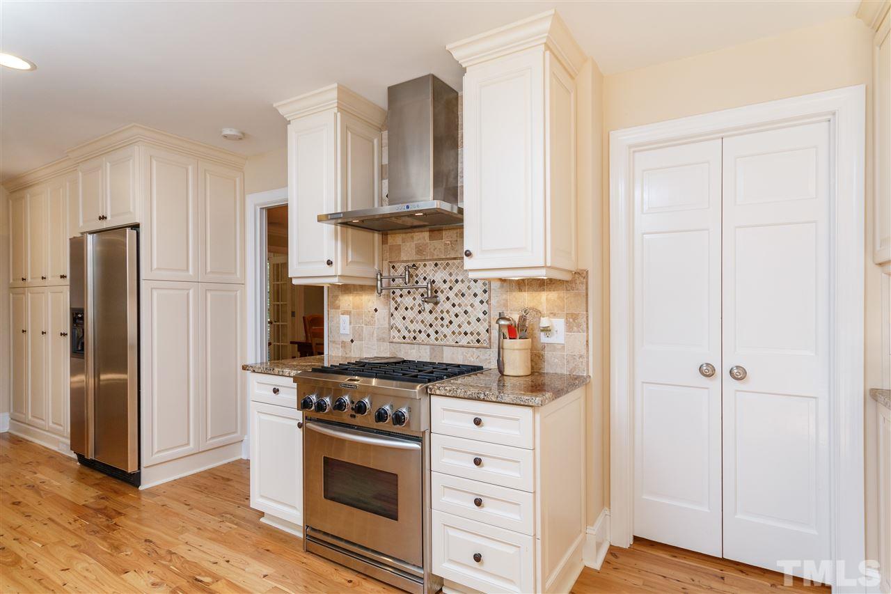 4921 Springwood Drive Raleigh, NC 27613 - Photo 9 of 25 a kitchen with white cabinets and appliances