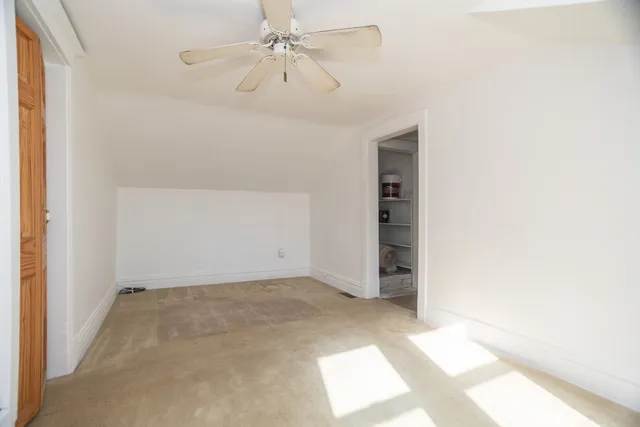 an empty room with a ceiling fan and a window
