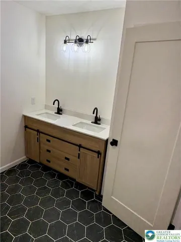 a bathroom with a double vanity sink and a mirror