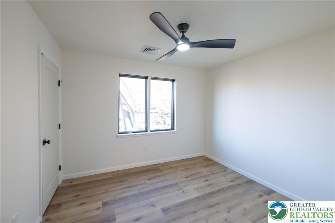 111 Main Street Glendon, PA 18042 - Photo 21 of 33 an empty room with wooden floor ceiling fan and windows