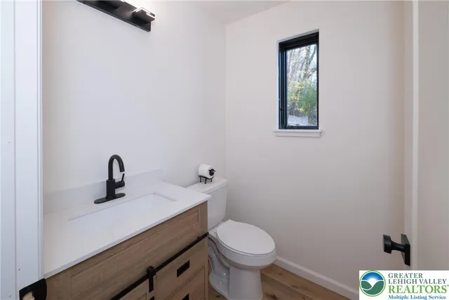 a bathroom with a sink a toilet and a window