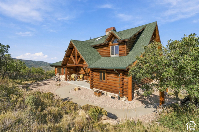 1701 Oak Road Coalville, UT 84017 - Photo 5 of 71 Log home featuring a green shingle roof, stone foundation, and wood siding