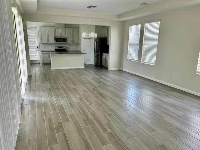 a view of kitchen with microwave a stove and wooden floor